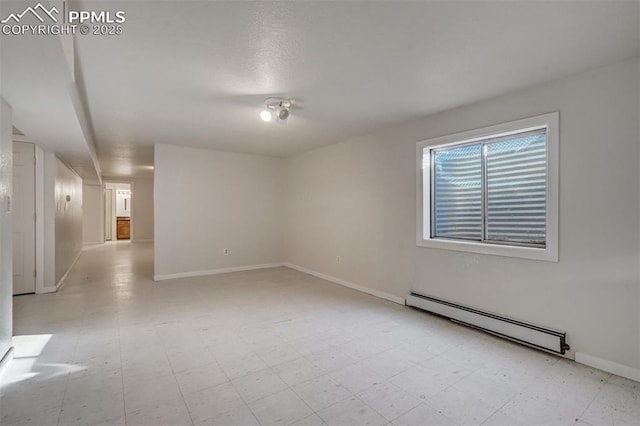 empty room featuring a baseboard radiator, baseboards, and light floors