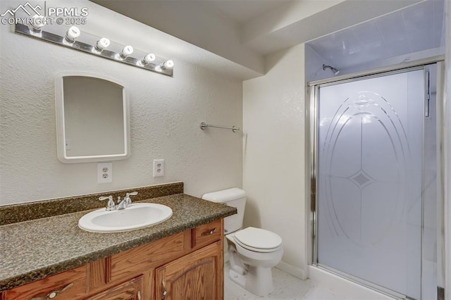 bathroom with toilet, a shower with door, a textured wall, and vanity