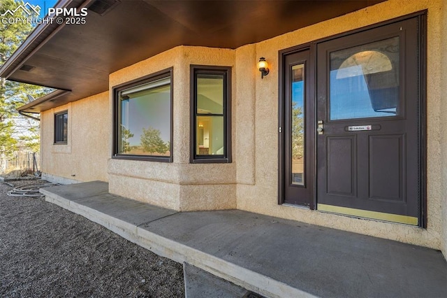 doorway to property featuring stucco siding