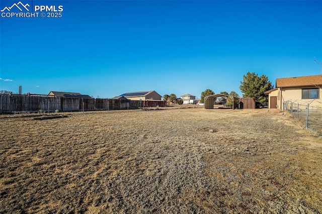 view of yard with an outbuilding, a fenced backyard, and a shed