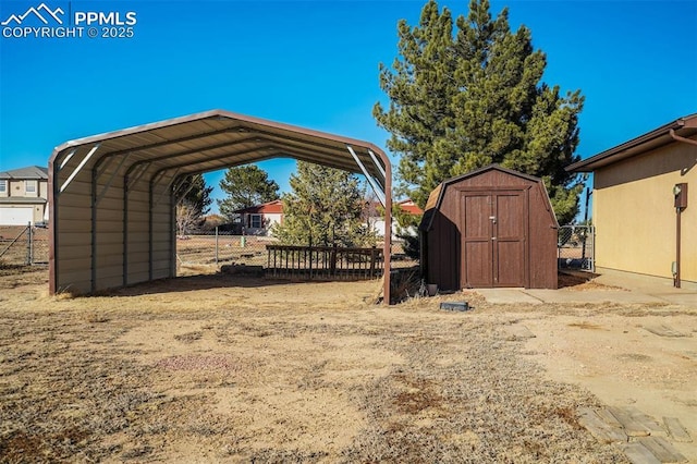 view of yard featuring a carport, a shed, an outdoor structure, and fence