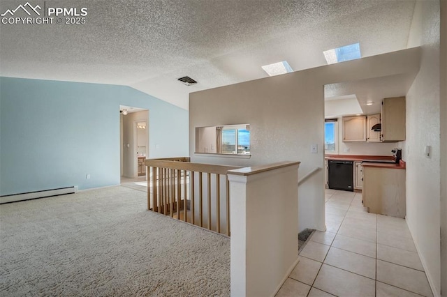 hall with light tile patterned floors, visible vents, lofted ceiling, baseboard heating, and an upstairs landing