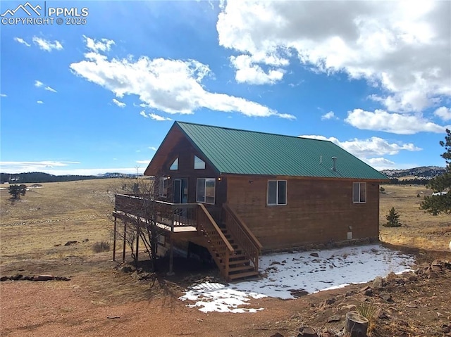 back of house with a deck, stairs, and metal roof