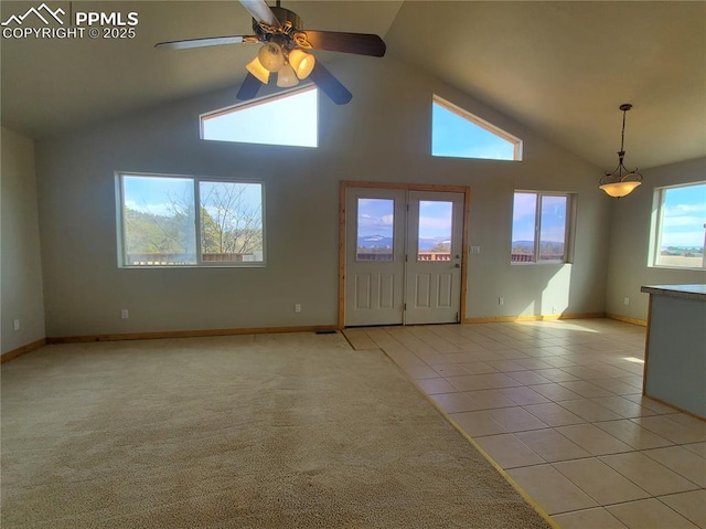 interior space with high vaulted ceiling, light colored carpet, light tile patterned flooring, and baseboards