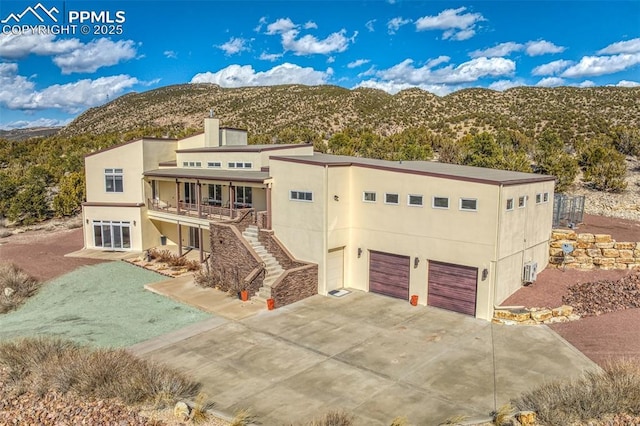 view of front of home with a mountain view, stairway, and stucco siding