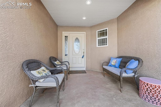 view of exterior entry featuring a patio area and stucco siding