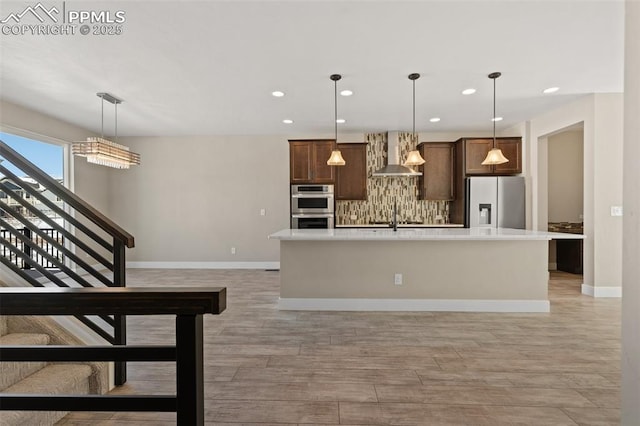 kitchen with stainless steel double oven, refrigerator with ice dispenser, light countertops, wall chimney exhaust hood, and tasteful backsplash