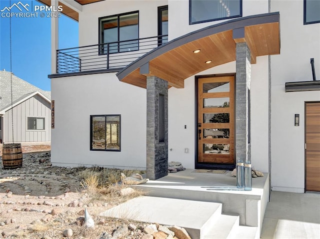 doorway to property featuring a balcony and stucco siding