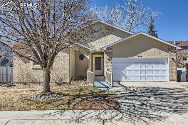 ranch-style house featuring a garage, stucco siding, driveway, and brick siding