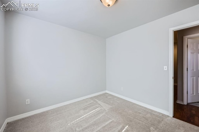 empty room featuring carpet flooring and baseboards