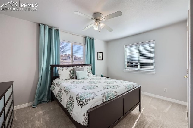 bedroom with light carpet, a ceiling fan, and baseboards