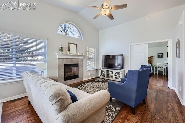 living room with ceiling fan, a fireplace, wood finished floors, and baseboards