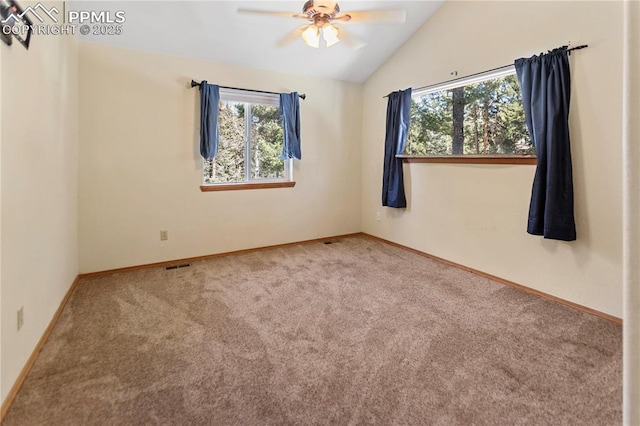 empty room with lofted ceiling, carpet, visible vents, and baseboards