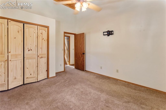 unfurnished bedroom with carpet, baseboards, ceiling fan, and a closet