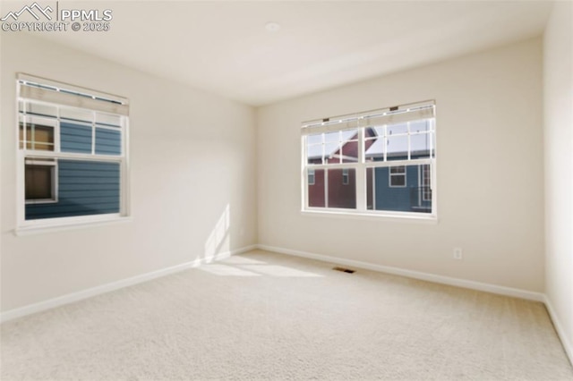 unfurnished room featuring baseboards, visible vents, and carpet flooring