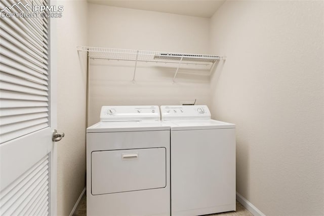 laundry area featuring laundry area, washing machine and dryer, and baseboards