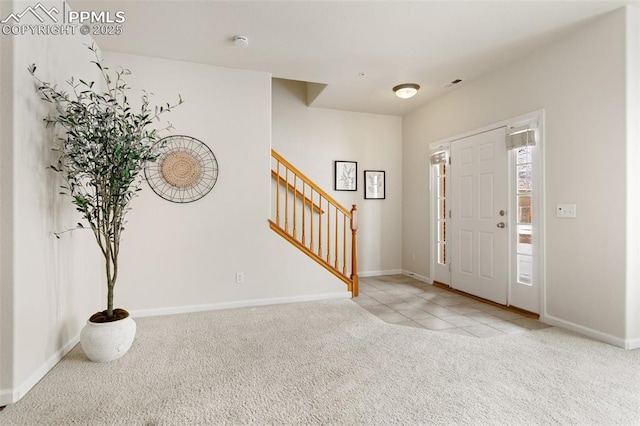 foyer entrance featuring light carpet, stairway, visible vents, and baseboards