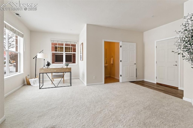 interior space featuring baseboards, visible vents, and carpet flooring