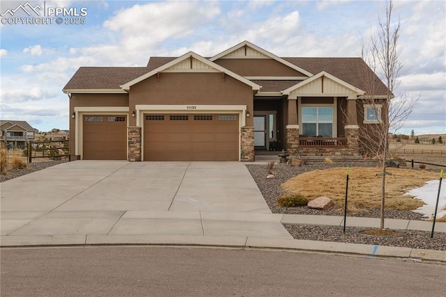 craftsman-style home featuring concrete driveway, stone siding, an attached garage, fence, and stucco siding