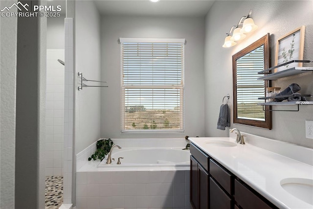 full bathroom with a tile shower, double vanity, a sink, and a bath