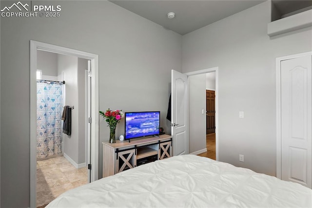 bedroom with baseboards and connected bathroom