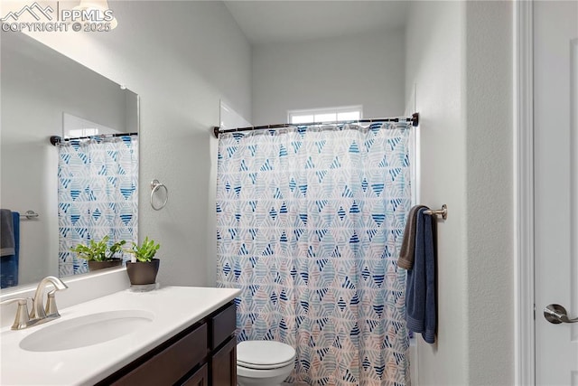 bathroom with a shower with shower curtain, vanity, and toilet