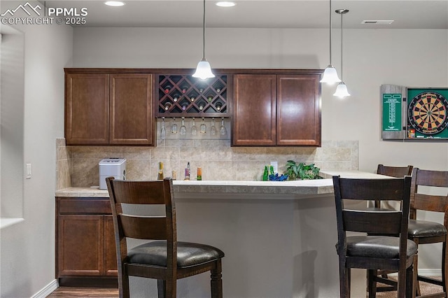 bar with a dry bar, visible vents, decorative backsplash, and decorative light fixtures