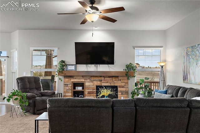 living room featuring a ceiling fan and a fireplace