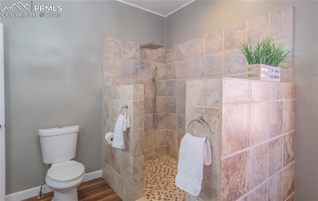 full bath featuring toilet, baseboards, a walk in shower, and wood finished floors