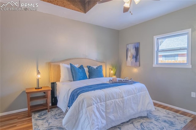 bedroom with wood finished floors, a ceiling fan, and baseboards