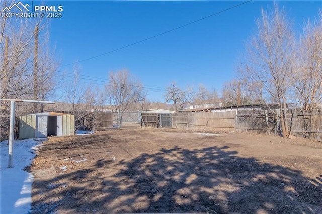 view of yard featuring an outdoor structure, a storage shed, and fence