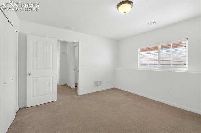 unfurnished bedroom with baseboards, a closet, visible vents, and light colored carpet