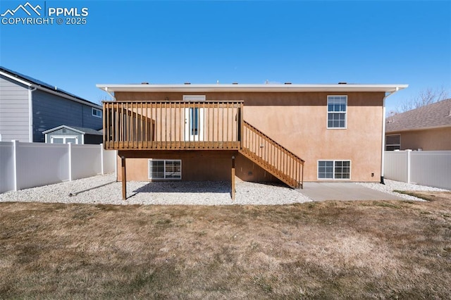 back of property with stairway, a fenced backyard, a wooden deck, and stucco siding