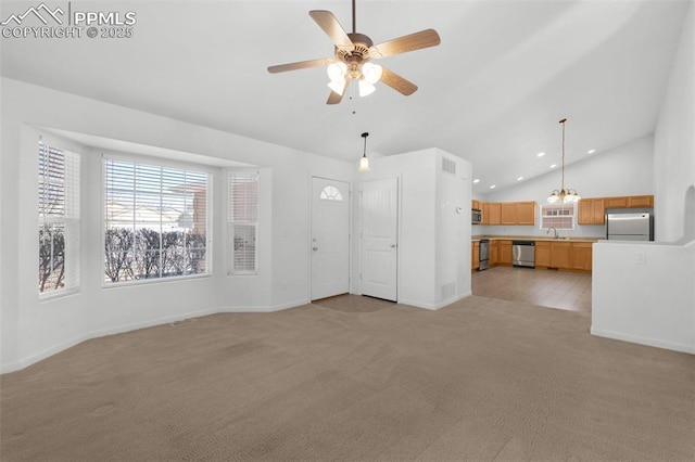 unfurnished living room with light colored carpet, lofted ceiling, ceiling fan with notable chandelier, a sink, and recessed lighting