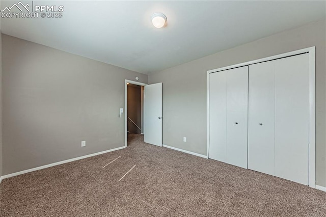 unfurnished bedroom with carpet floors, a closet, and baseboards