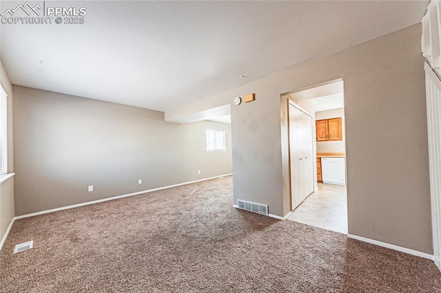 spare room with baseboards, visible vents, and light colored carpet