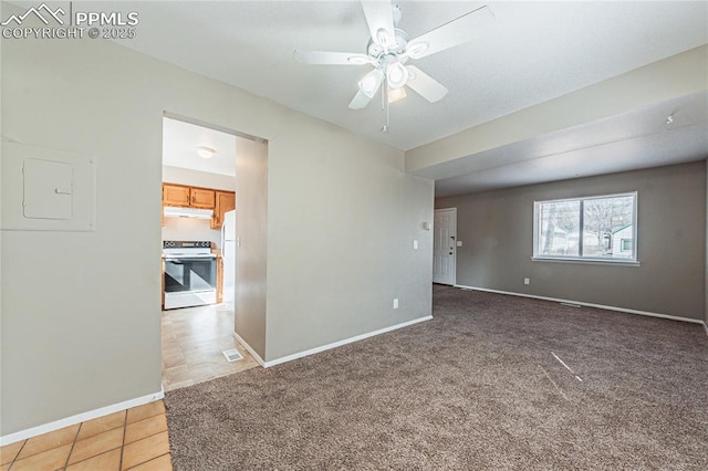 carpeted empty room featuring visible vents, electric panel, a ceiling fan, and baseboards