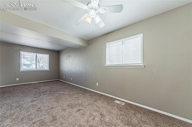 carpeted empty room featuring baseboards, visible vents, and ceiling fan