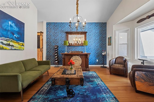 20290 Doewood Dr, Monument, CO 80132 - living area with wallpapered walls, a barn door, an accent wall, and an inviting chandelier