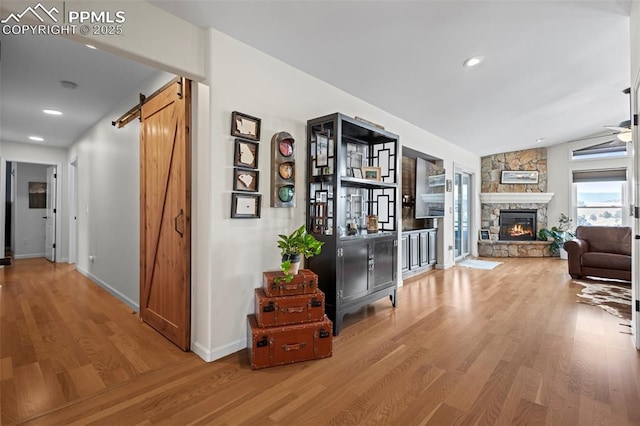 20290 Doewood Dr, Monument, CO 80132 - hall with recessed lighting, wood finished floors, baseboards, and a barn door