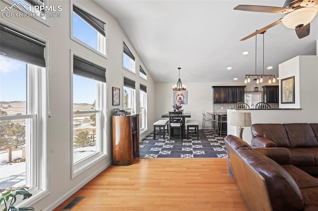 20290 Doewood Dr, Monument, CO 80132 - living room with lofted ceiling, recessed lighting, ceiling fan with notable chandelier, visible vents, and light wood-type flooring