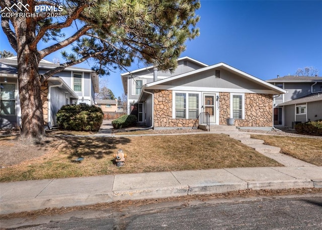 view of front of house with stone siding and a front lawn