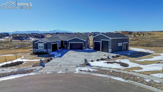 view of front of property with a garage, stucco siding, driveway, and a mountain view