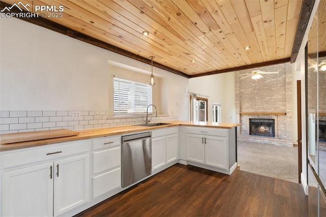 kitchen featuring butcher block countertops, white cabinets, open floor plan, dishwasher, and decorative light fixtures