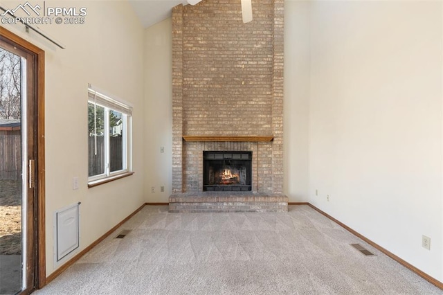 unfurnished living room with high vaulted ceiling, light carpet, a fireplace, and baseboards