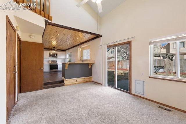 unfurnished living room with light carpet, visible vents, and a ceiling fan