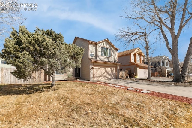 traditional-style house featuring driveway, an attached garage, fence, and a front lawn