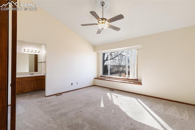 unfurnished bedroom featuring visible vents, baseboards, connected bathroom, and light colored carpet