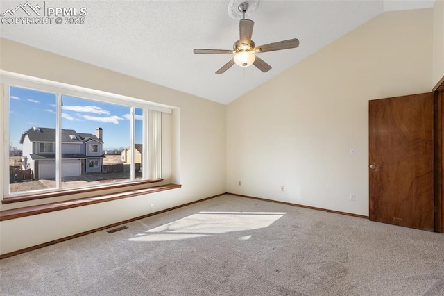 spare room with light colored carpet, visible vents, a ceiling fan, high vaulted ceiling, and baseboards