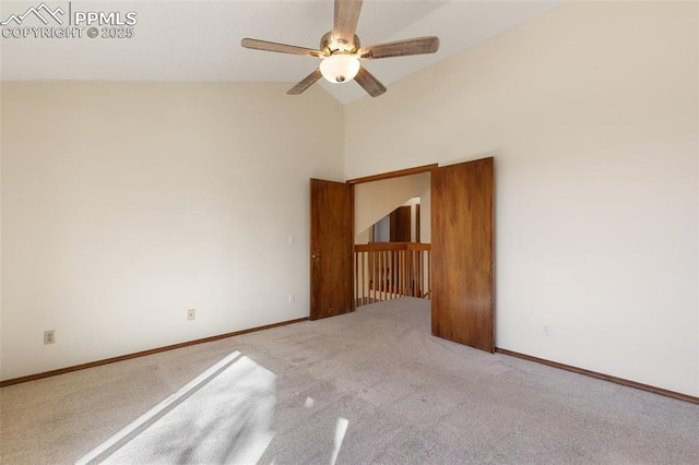 empty room with high vaulted ceiling, a ceiling fan, baseboards, and carpet flooring